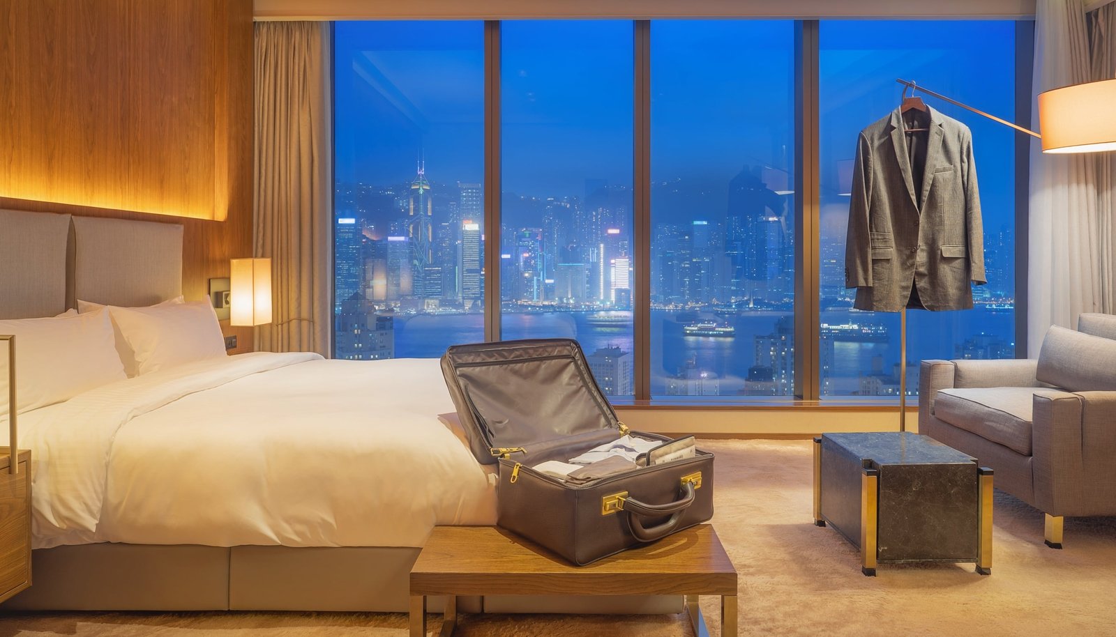Luxury Hong Kong hotel room overlooking Victoria Harbour and the illuminated city skyline at dusk
